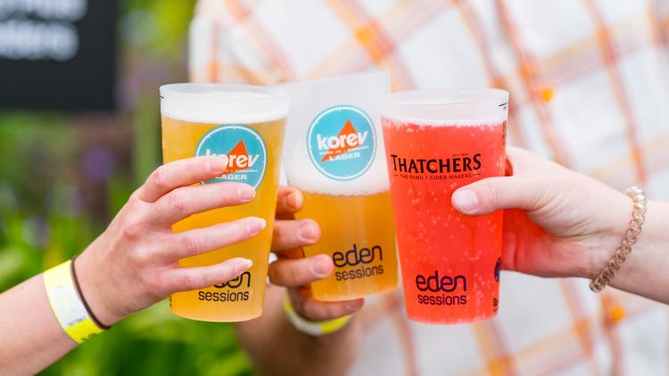 Hands holding Eden Sessions pint cups