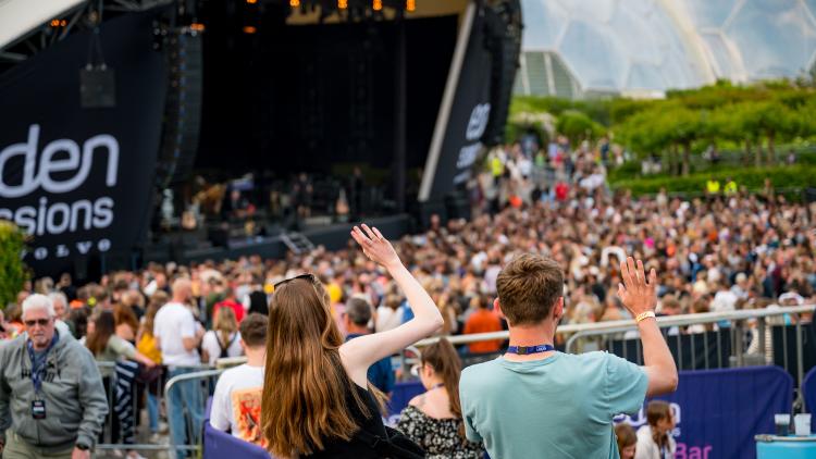 People with the arms up enjoying the music in the Eden Sessions Plus Garden Bar